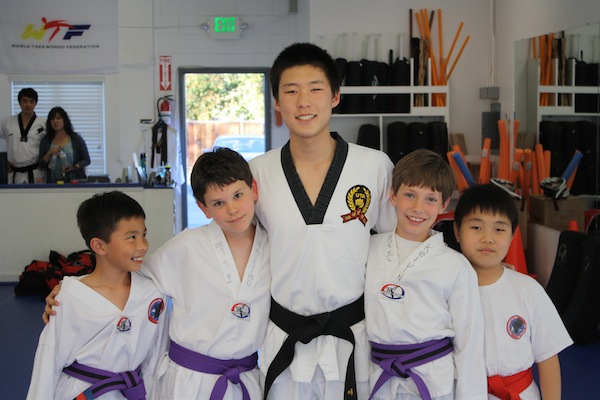 Johnny Lee ('15) poses with his taekwondo students at Palo Alto Martial Arts.
